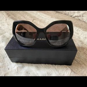 Black Prada sunglasses with brown tinted lenses.